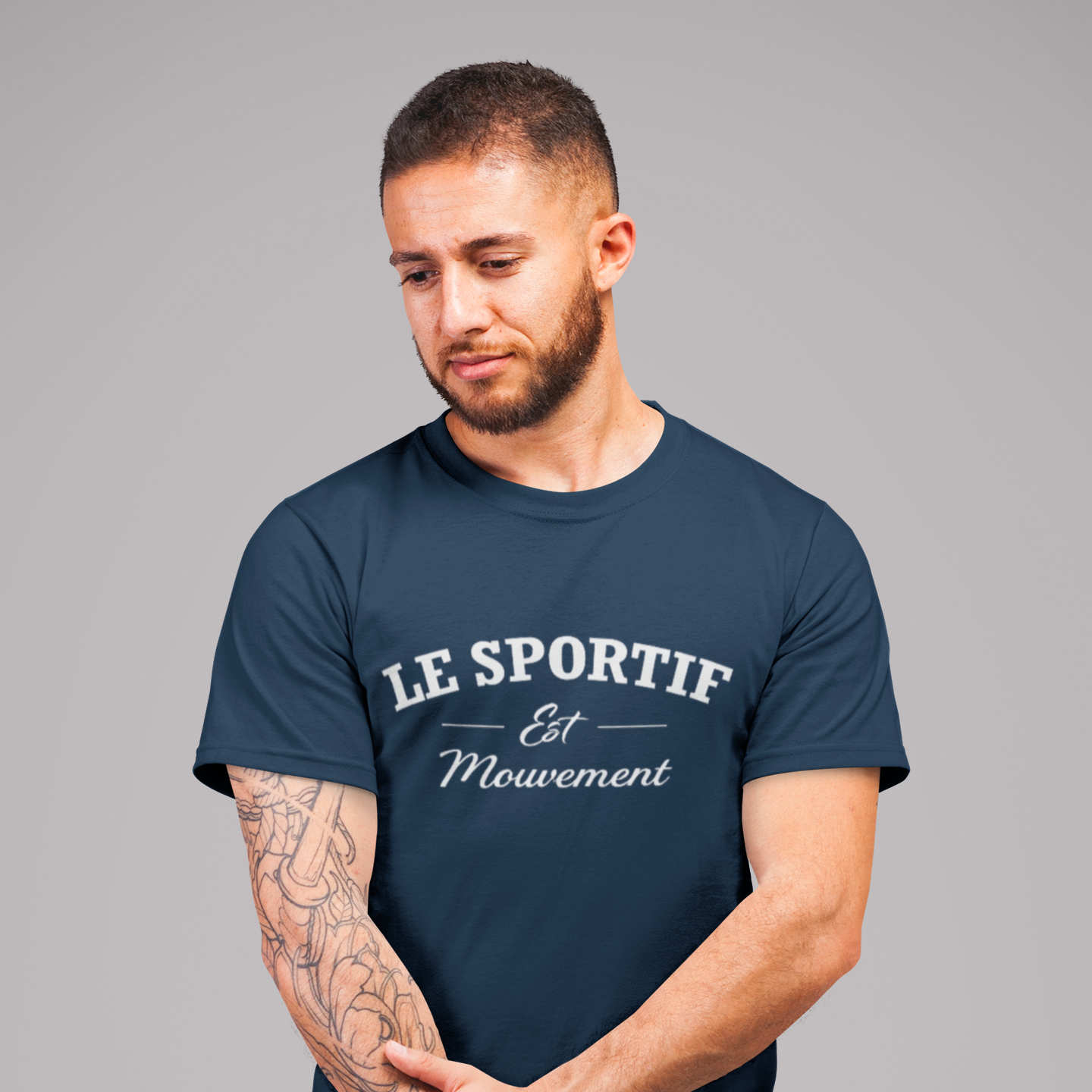 Man wearing a navy blue t-shirt with white text on a gray background